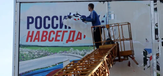 В ОСВОБОЖДЕННОМ ХЕРСОНЕ СРЫВАЮТ ПЛАКАТ «РОССИЯ ЗДЕСЬ НАВСЕГДА» 14 НОЯБРЯ 2022. ФОТО: AFP / SCANPIX / LETA
