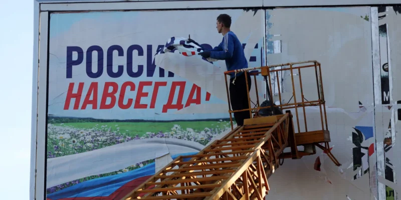 В ОСВОБОЖДЕННОМ ХЕРСОНЕ СРЫВАЮТ ПЛАКАТ «РОССИЯ ЗДЕСЬ НАВСЕГДА» 14 НОЯБРЯ 2022. ФОТО: AFP / SCANPIX / LETA