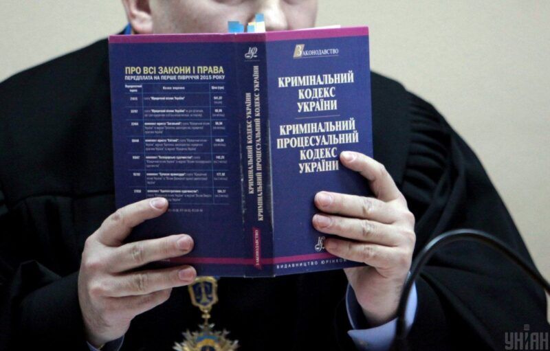 Судья Подольского райсуда Киева Юрий Зубец держит экземпляр Уголовного кодекса Украины во время рассмотрении дела по существу против экс-командира роты харьковского подразделения «Беркута» Виктора Шаповалова Фото: УНИАН/Сергей Нужненко